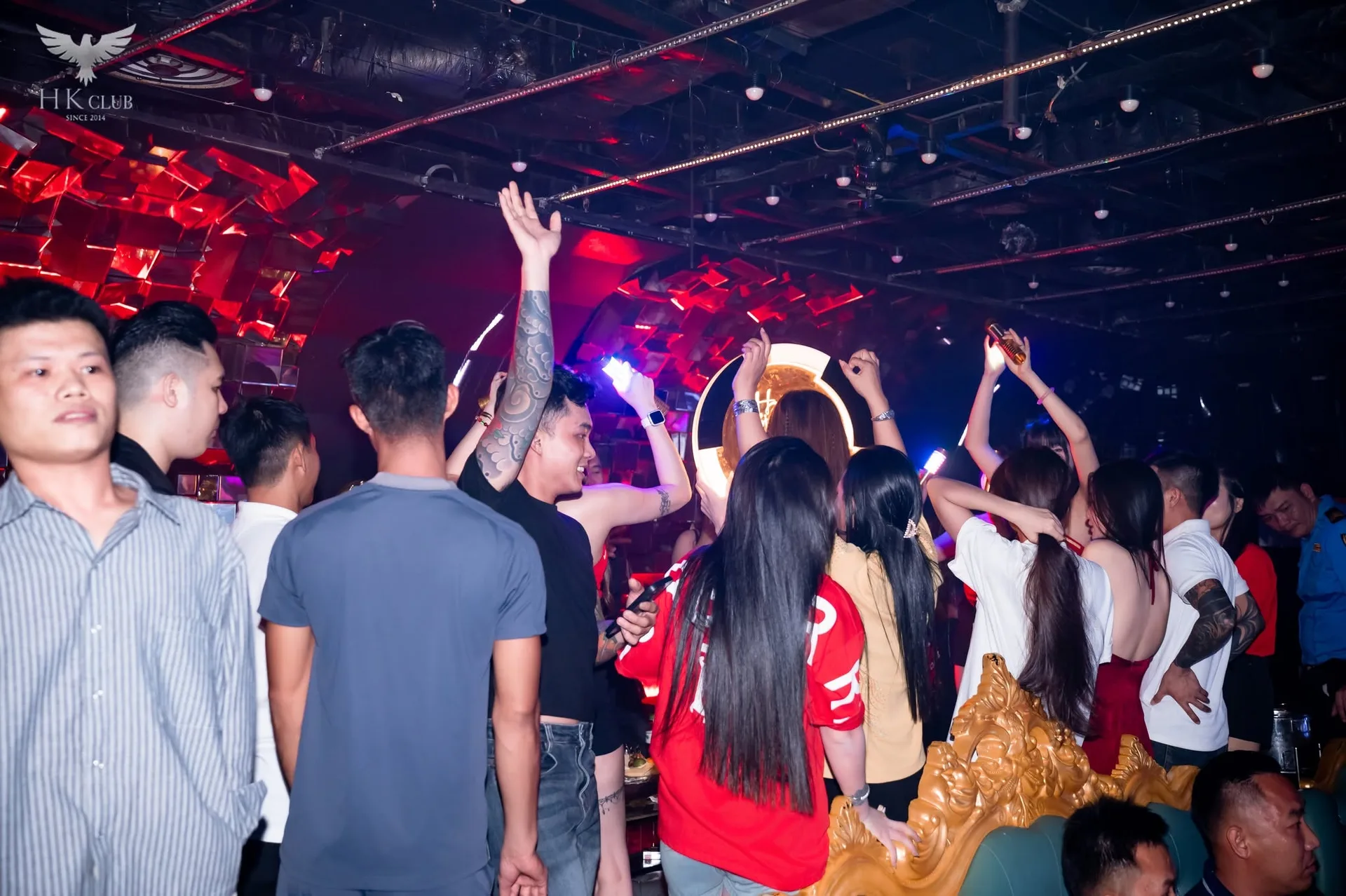 Tường khối gương đỏ và sofa lưng chạm vàng tại HK Club